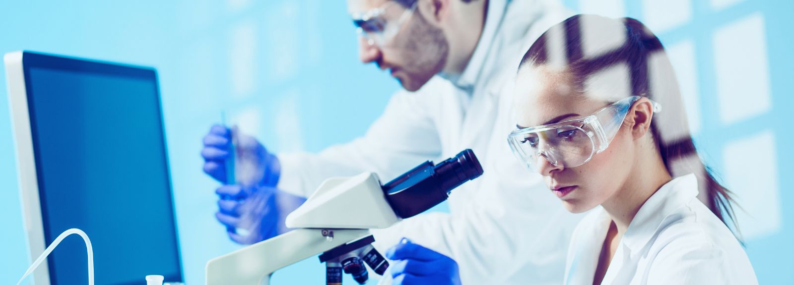 two scientists in a lab using lab equipment